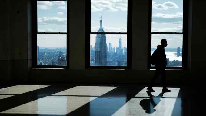 People enjoy the view from the top of Rockefeller Center as office buildings stand largely empty in New York City