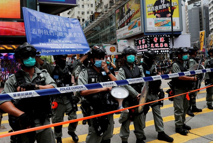 Riot police stand in line as anti-national security law protesters march on the anniversary in July 2020 of Hong Kong’s handover to China from Britain