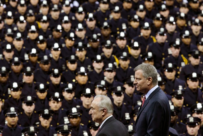 New York City Mayor Bill de Blasio, right, and NYPD commissioner William Bratton at a police graduation ceremony. Mr Bratton introduced the 'broken windows' policing approach, while Mr de Blasio made opposition to 'stop-and-frisk' a centrepiece of his campaign in 2013