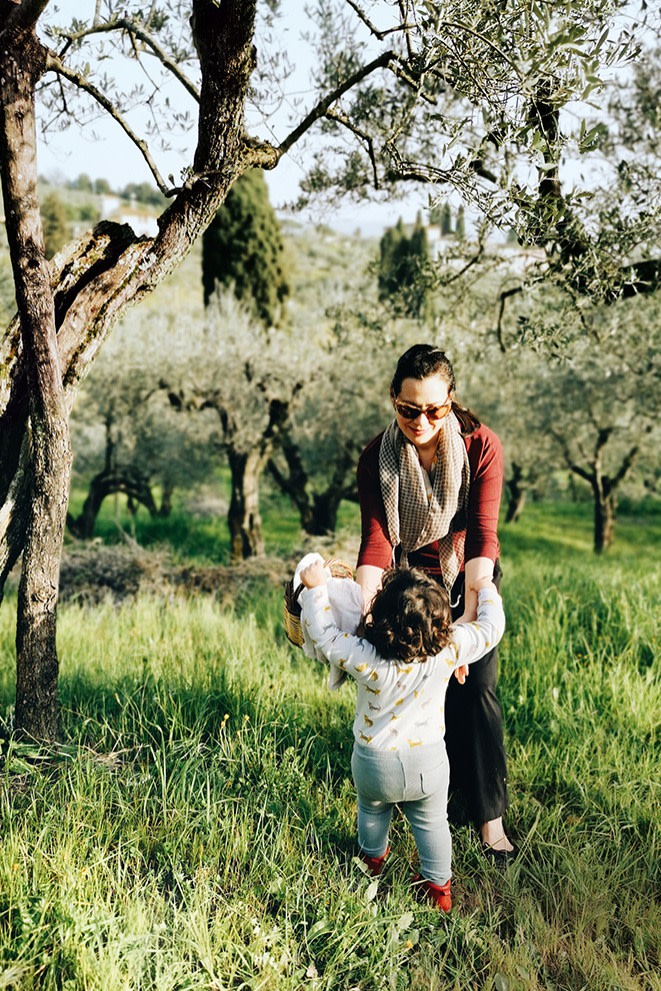 Emiko and her daughter Luna among olive trees near their home