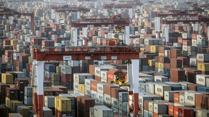 Shipping containers next to gantry cranes in Shanghai, China
