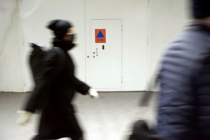 A commuter passes a door to a civil defence shelter in Helsinki 