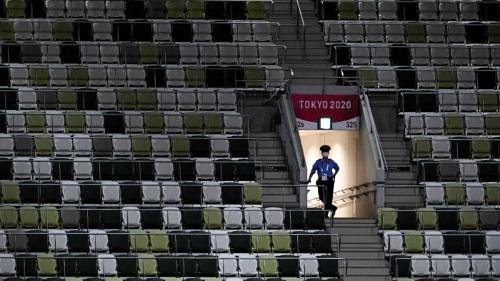 A police officer is seen in the empty stands ahead of the opening ceremony of the Tokyo 2020 Olympic Games