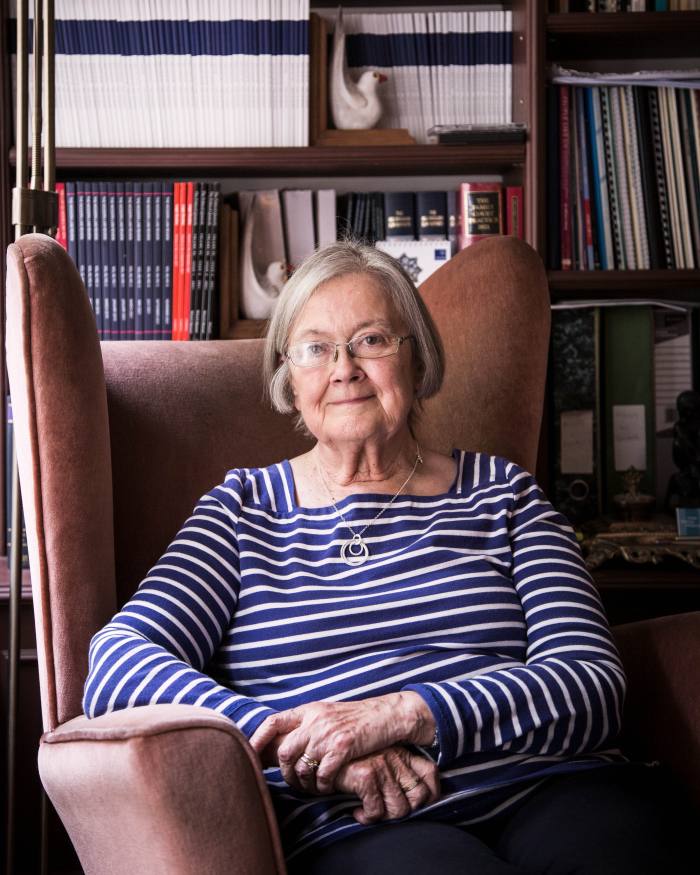 Brenda Hale, a woman sitting on a large leather chair. Behind her is a shelf filled with books