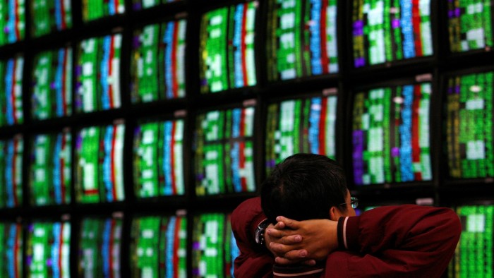 A man looks at stock market screens in Taipei