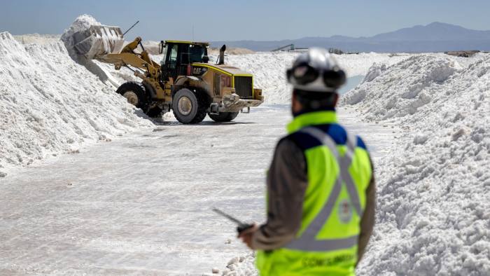 Lithium mine workers move salt bi-product at a lithium mine in the Atacama Desert