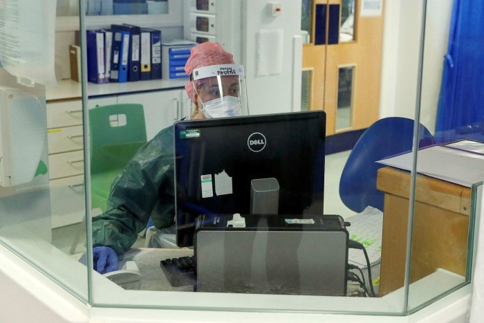 A physiotherapist sits at a workstation in an intensive care ward at Frimley Park Hospital in Surrey