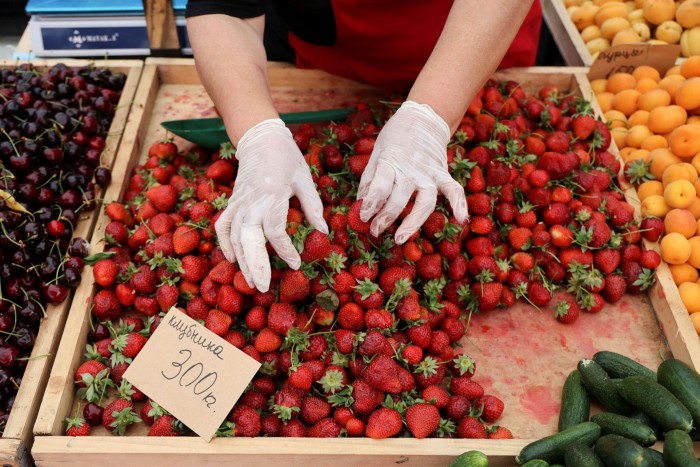 A woman sorts strawberries on a market stall in Kashira, a Russian town