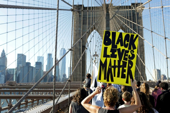 A demonstrator holds a ‘Black Lives Matter” sign while participating during the March for Racial Justice on the Brooklyn Bridge