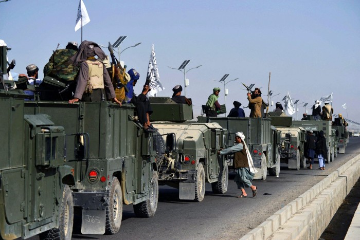 Taliban fighters atop Humvee vehicles