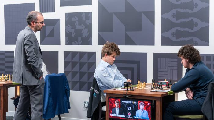 Magnus Carlsen and Hans Niemann face one another at a chess board