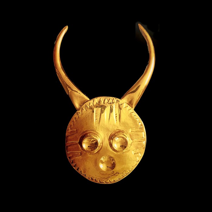 A small golden disk with three indentations and a pair of horns