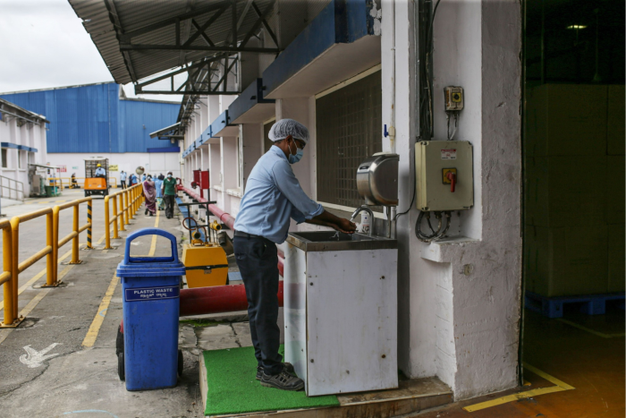 A worker stands at a sink to wash his hands at a Diageo plant in India