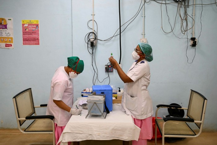 A health worker prepares a dose of the AstraZeneca vaccine at a hospital in Mumbai 