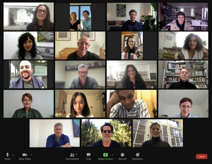 A screenshot of a Zoom video call with many small squares of people’s faces