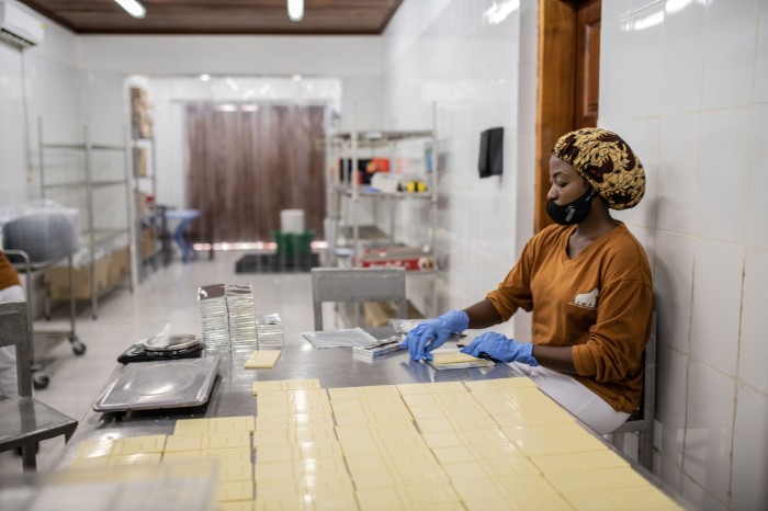 A woman wraps white chocolate in Virunga Chocolate’s Mutwanga factory