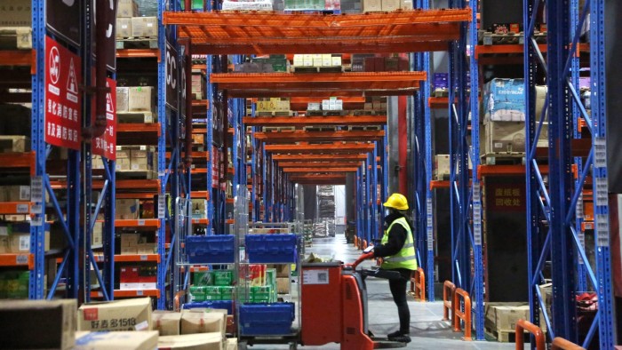 A staff member delivers goods according to an order at a warehouse of an e-commerce logistics park in Lianyungang, East China’s Jiangsu Province,