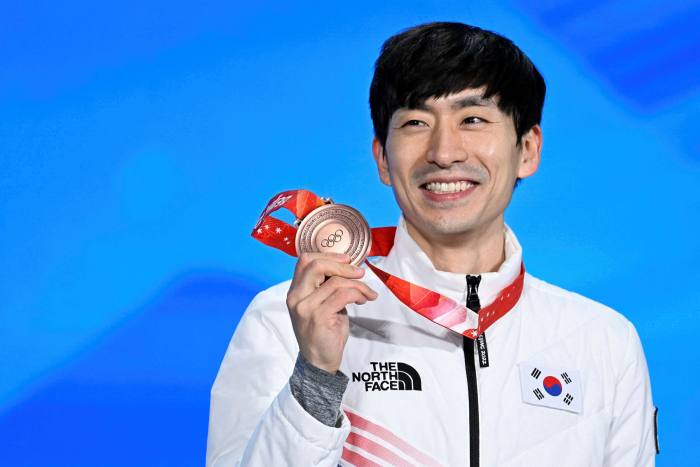 Bronze medallist South Korea’s Lee Seung-hoon pose on the podium during the men’s speed skating mass start victory ceremony of the Beijing 2022 Winter Olympic Games