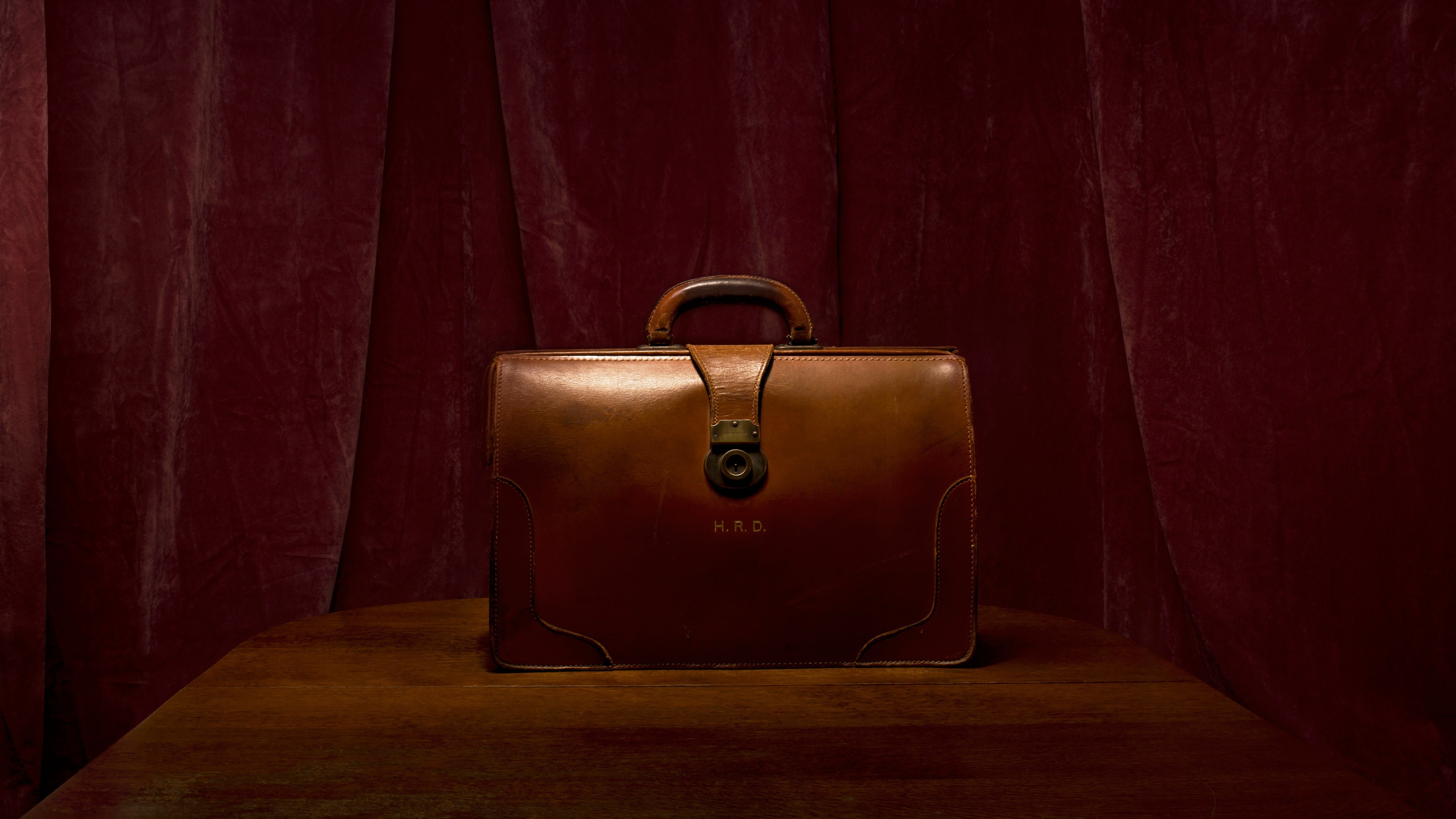 A brown, leather bag with the initials H.R. D.
