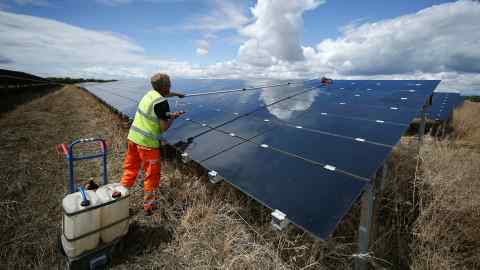 A workman cleans panels at Landmead solar farm