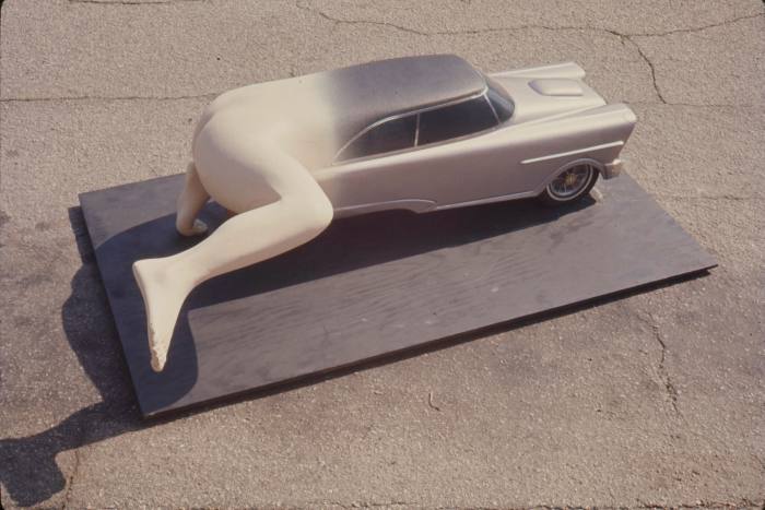 Sculpture of a car turning into a man’s lower half, with one leg cocked