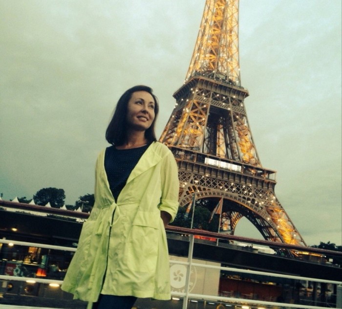 Lyubov Prigzhin wearing a light green coat pictured in front of the Eiffel Tower