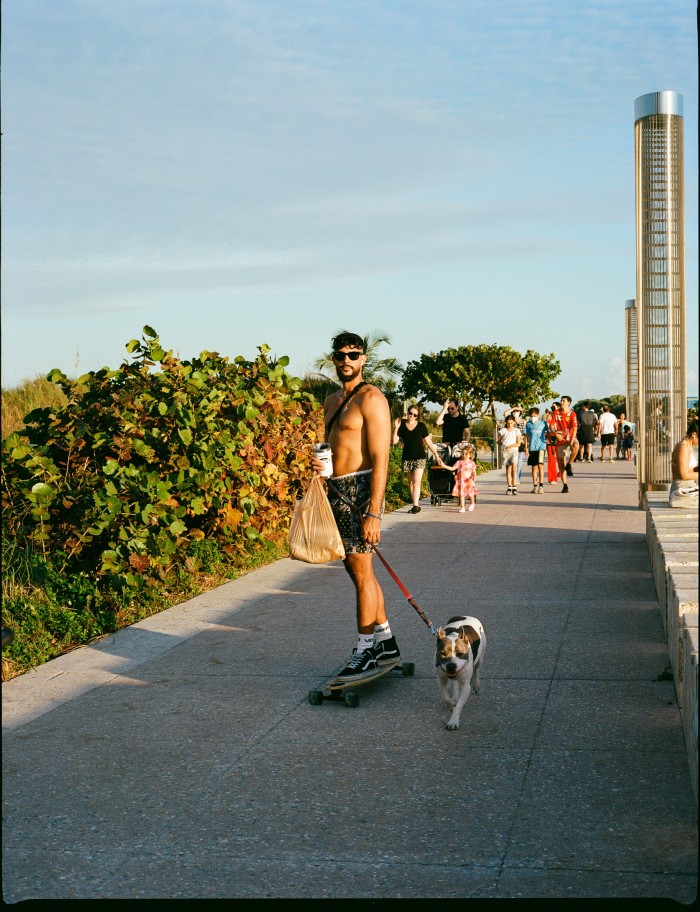 A skateboarder and his dog on the Boardwalk at South Pointe Park