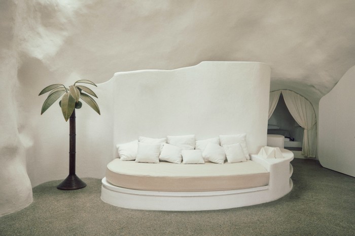 A day bed beside a vintage 1970s palm tree lamp by  Mario Lopez Torres