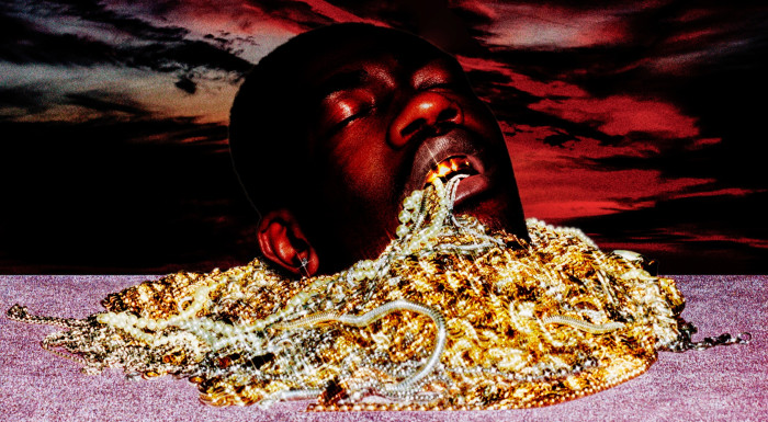 The head of a young man wearing golden grills rises from a mix of golden and silver jewellery as well as pearls against a glittery pink foreground and a sunset background