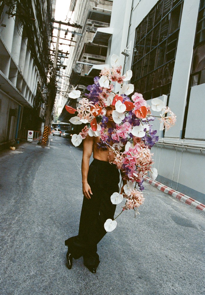 Revenue and distribution executive analyst Piya Leo Fyot, 23, wears Saint Laurent by Anthony Vaccarello grain de poudre trousers, £1,415, and patent-leather Derby shoes, £785. Eric Tobua handmade faux-flower, wire and velvet-ribbon Wearable Flowers headpiece, £240. Talat Phlu district