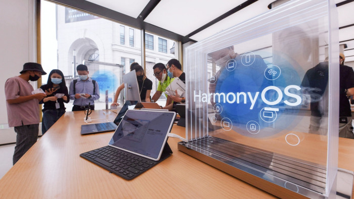A Huawei tablet with the HarmonyOS logo beside it
