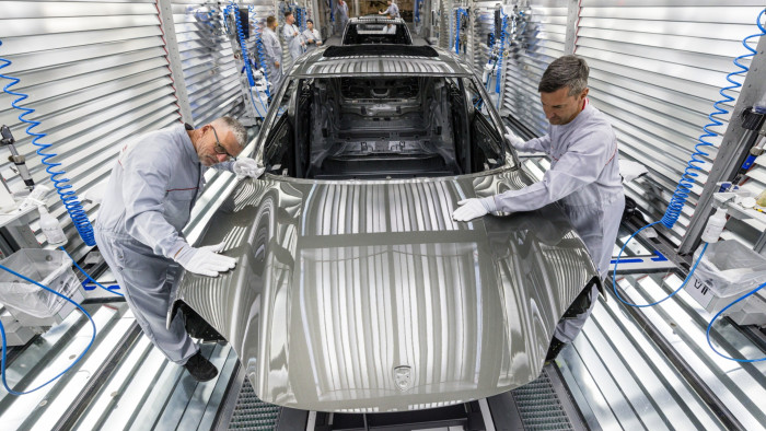 Workers assemble the all-electric Porsche Macan at the Porsche assembly plant in Leipzig, Germany