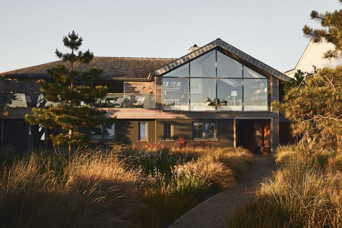 The Jonathan Reed-designed house has an upstairs living space with floor-to-ceiling windows. Garden design by Ben Rigby