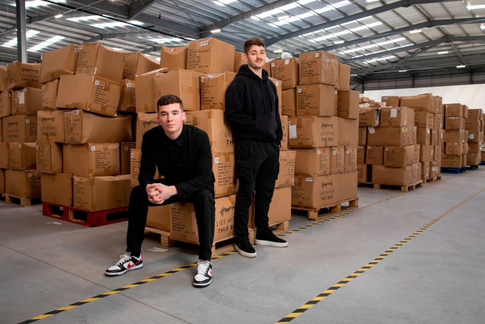 Kristian and Reiss Edgerton standing in a warehouse full of boxes