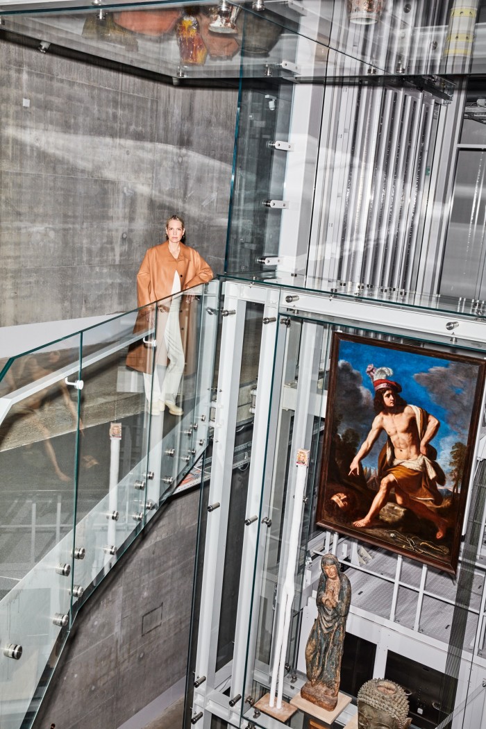 Marcelis on an elevated walkway inside the Depot Boijmans Van Beuningen, with a religious painting and icon below her to the right