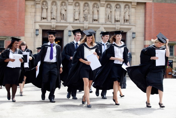 Graduates leave the Great Hall after a degree ceremony at Birmingham University UK