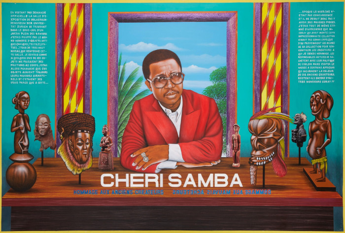 In a painting, a middle-aged man wearing shades, a red jacket and a white shirt sits at the desk surrounded by anthropomorphic statuettes. Below him, we read ‘CHERI SAMBA’ in white capital letters   