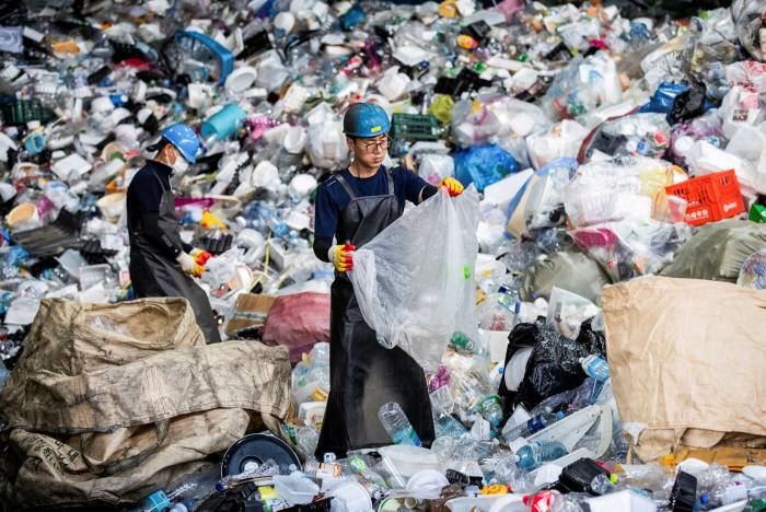 Workers sort plastic waste at Yongin Recycling Center in Yongin, South Korea