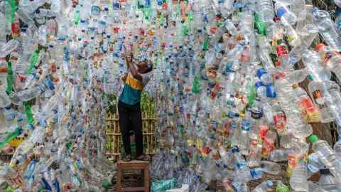 An Indonesian activist from ECOTON (ecological observation and wetland conservation) prepares an installation made with used plastic, including 4,444 bottles