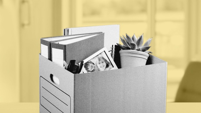 Black and white image of a box of personal effects on a desk in an office