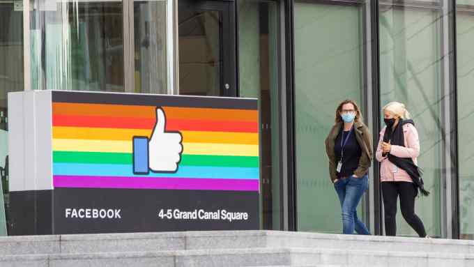 Two women walk by Facebook’s office in Dublin