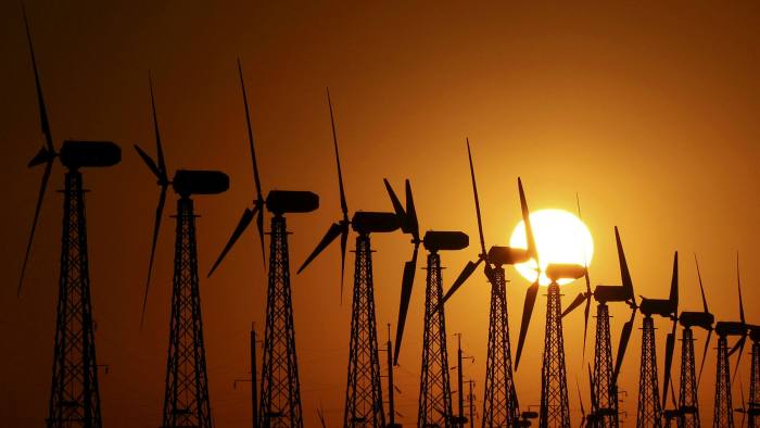 The sun sets behind power-generating turbines of a local wind farm in the settlement of Mirnyi, Crimea