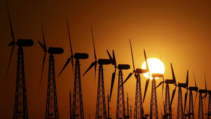 The sun sets behind power-generating turbines of a local wind farm in the settlement of Mirnyi, Crimea