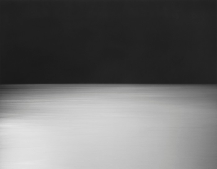 An abstract image is divided into a top black swathe and a blurred bottom one featuring different shades of grey