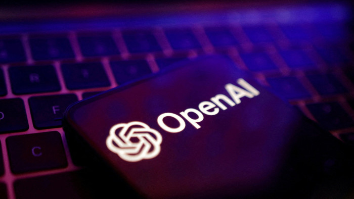 OpenAI logo on a hone on top of a keyboard