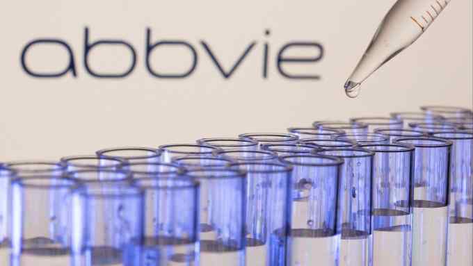 Test tubes are seen in front of a displayed Abbvie logo