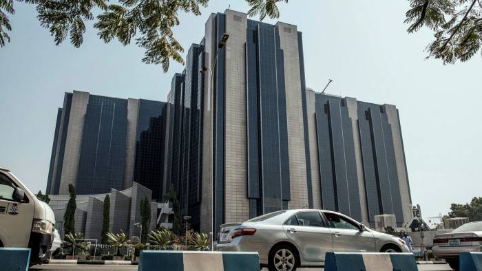 Automobiles drive past the headquarters of the Nigerian central bank in Abuja, Nigeria