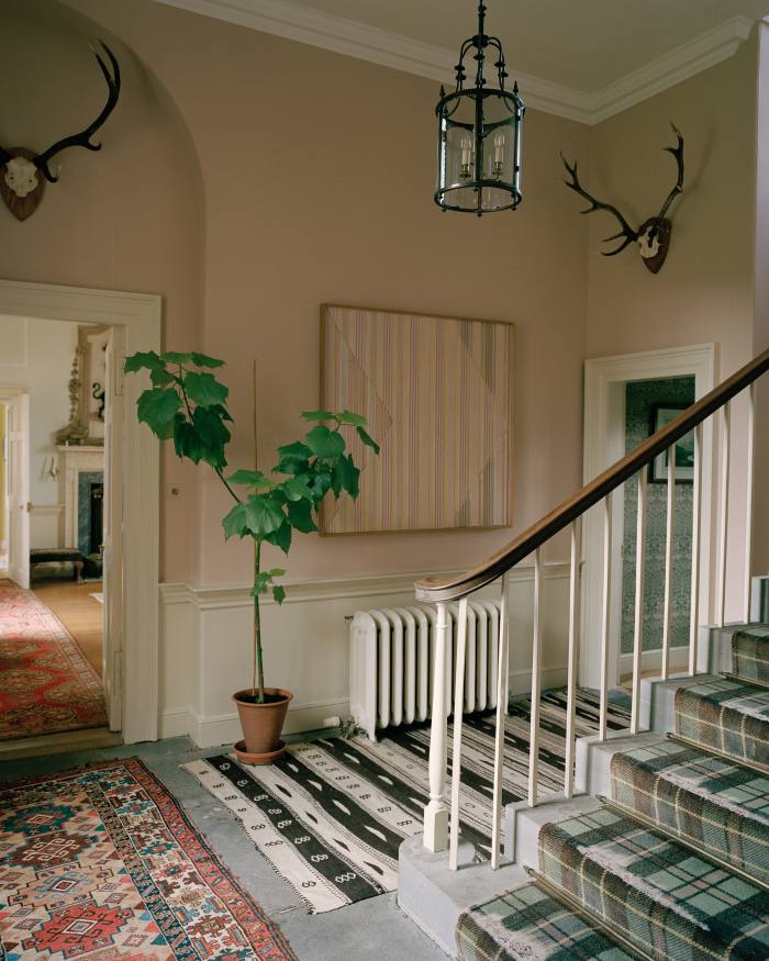 An intricate cut-paper and balsa-wood artwork by Kings hangs in the hallway. The stair runner is the Ogilvy tartan