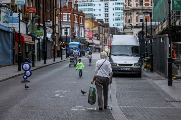Pedestrians pass vacant spots for stallholders at Surrey Street Market in Croydon