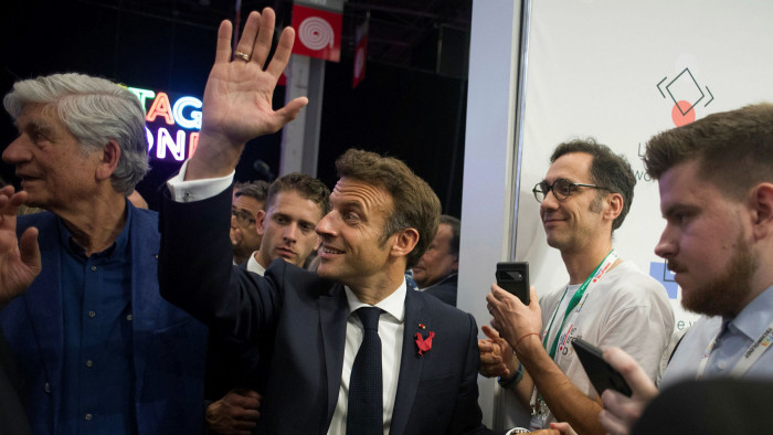 Emmanuel Macron greets attendees at a conference in Paris